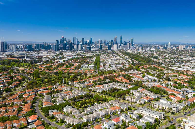 Aerial photo of Melbourne CBD and luxury homes in a suburb nearby